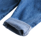 Close-up of a rolled-up blue denim pant leg showing the fabric texture and stitching on a white background.