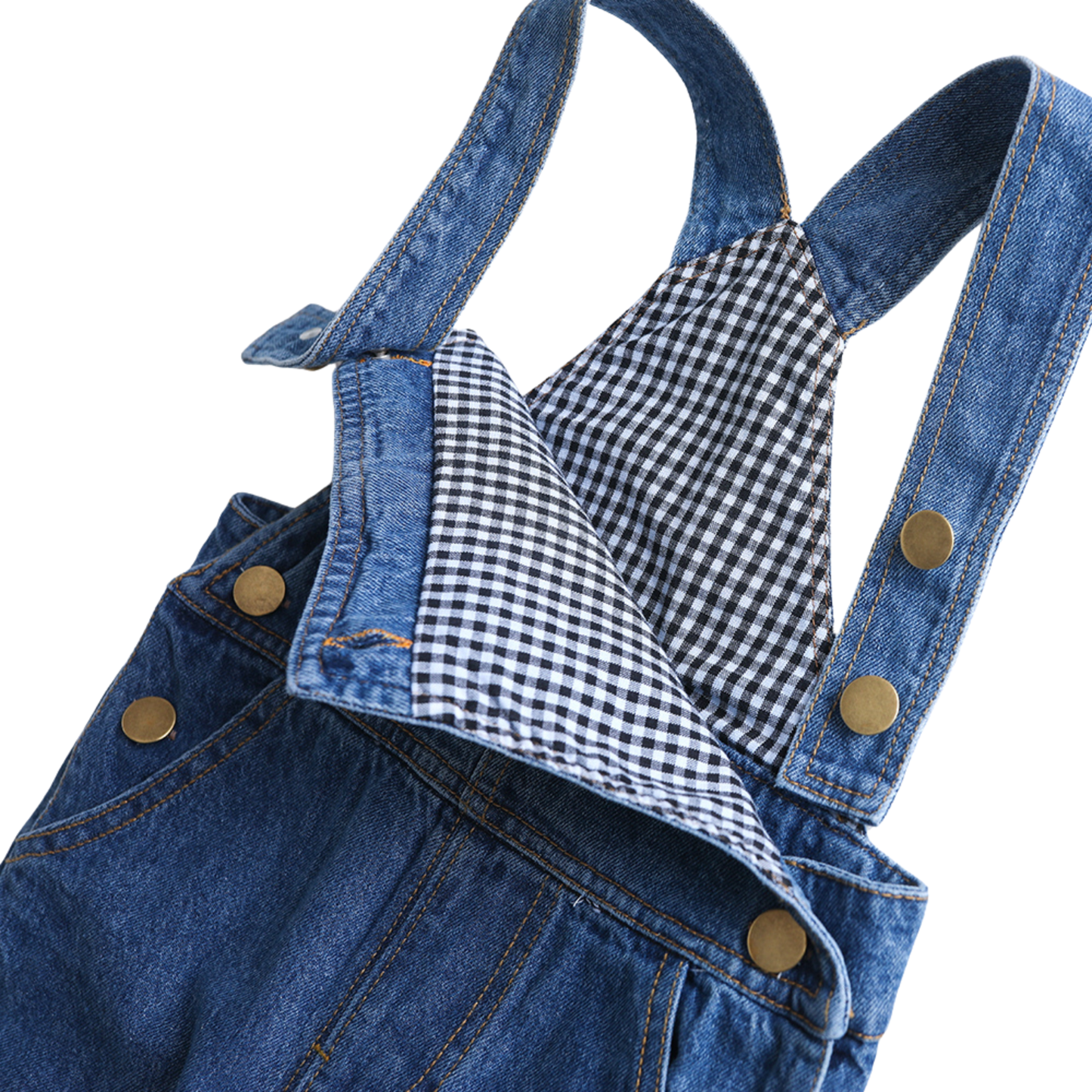 Close-up of a blue denim overall with adjustable straps, gold-tone snap buttons, and a black-and-white gingham lining visible at the neckline, photographed on a white background.